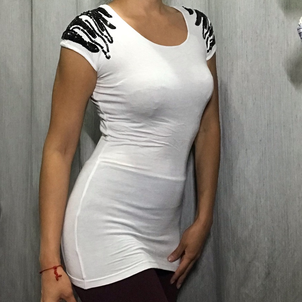 White top with black sequins on the shoulders